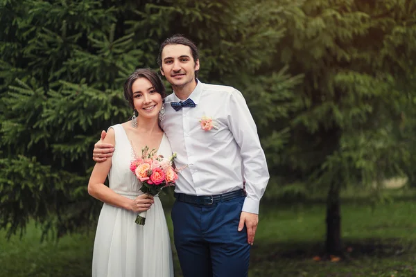 Gelukkig vrolijke glimlachend net getrouwd paar staande in park — Stockfoto