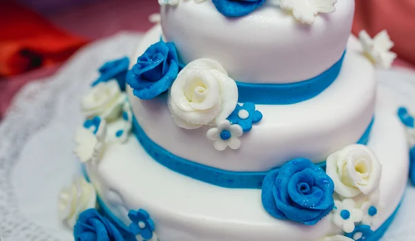 婚礼蛋糕装饰着接待桌上的花朵 — 图库照片