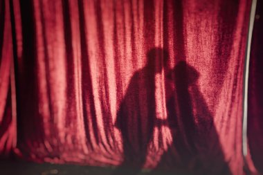 Gölgelerin içinden kırmızı kumaş üzerine öpüşme Çift