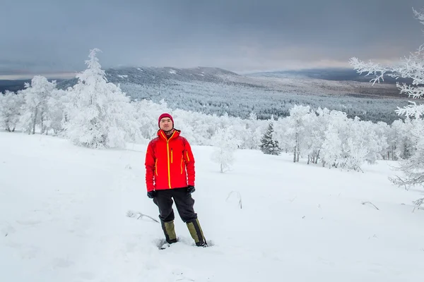 Touristin in heller Kleidung gegen den Winterwald bei Sonnenuntergang — Stockfoto