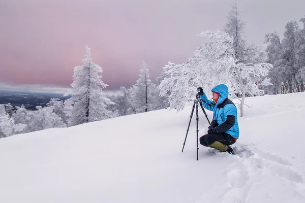 Fotógrafo en niebla paisaje de invierno con trípode —  Fotos de Stock