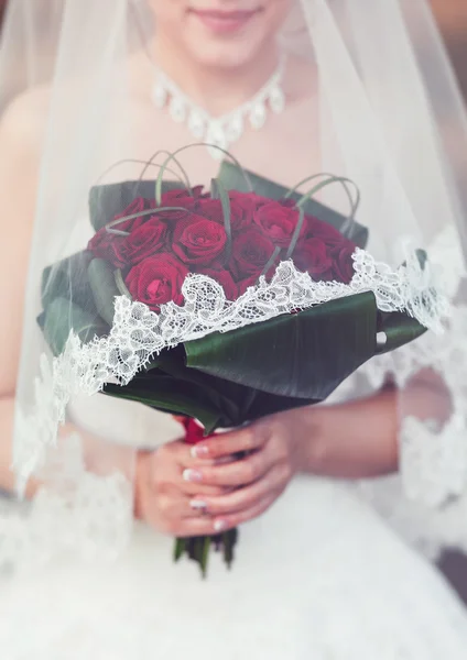 Panna młoda trzyma jej ślub czerwony bukiet kwiatów — Zdjęcie stockowe