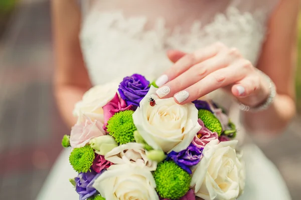 Невеста держит цветной свадебный букет цветов с божьей коровкой на — стоковое фото