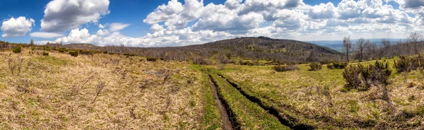 Voorjaar panorama heuvels met een onverharde weg — Stockfoto