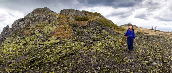 Panoramisch zicht van vrouw wandelaar op een rotsachtige berg. Lente wandeling door de heuvels van de zuidelijke Oeral — Stockfoto