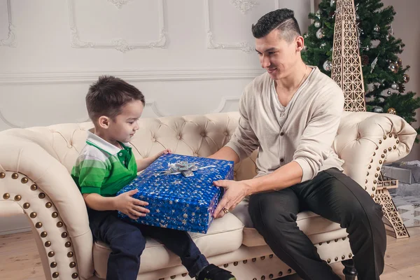 Père donne un cadeau à son fils sous le sapin de Noël — Photo