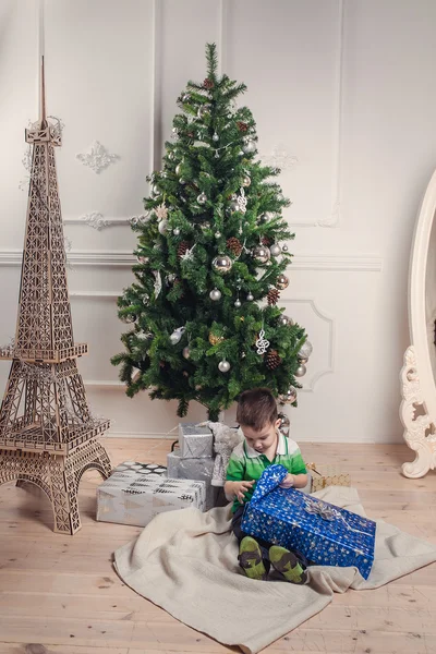 Mignon bébé garçon assis sous décoré arbre de Noël déballonne le — Photo