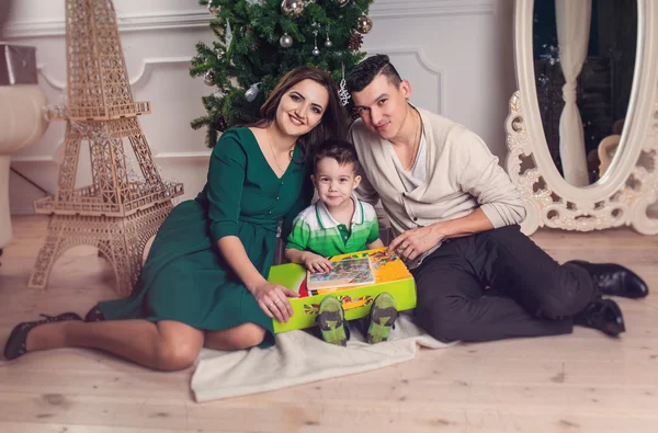 Joyeux parents et enfants de la famille avec des cadeaux près du sapin de Noël . — Photo