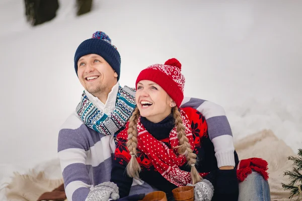 Ungt par i varma tröjor på vintern titta på himlen — Stockfoto