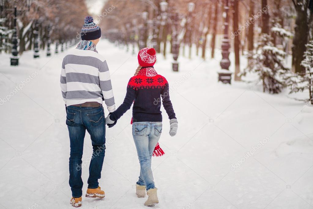 Rear view of young couple walking in winter park