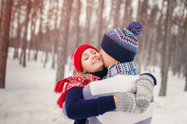 Glad i kärlek paret leende och kramas i Vinterparken — Stockfoto