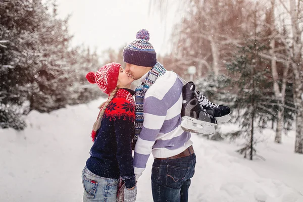 Casal amoroso beijando em um encontro em um parque de inverno. Na parte de trás — Fotografia de Stock