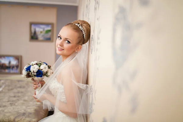 Un retrato de la novia rubiaen un vestido de novia con velo, y ramo — Foto de Stock