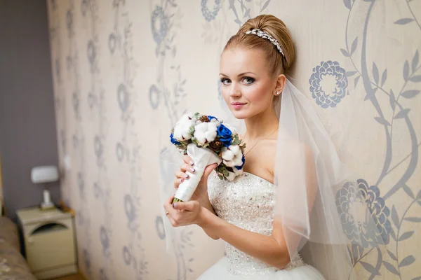 Joven novia atractiva en vestido de novia posando en el interior — Foto de Stock