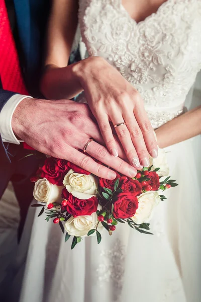 Manos novia y novio con anillos en el primer ramo —  Fotos de Stock