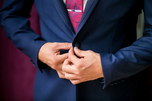 ビジネスの男性は紫色の背景に彼のジャケットをボタンします。 — ストック写真