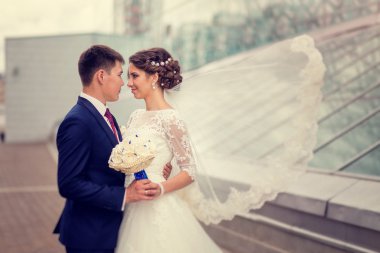 Birkaç aşk gelin ve damat kucaklama bir arka plan üzerinde içinde kentsel 