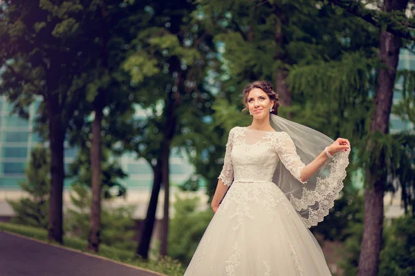 Невеста в парке с кружевной вуаль с копировальным пространством — стоковое фото