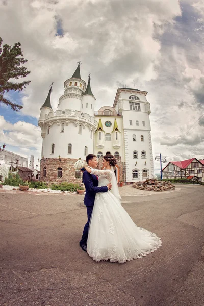 Elegáns menyasszony és a vőlegény, átölelve a háttérben, a modern — Stock Fotó