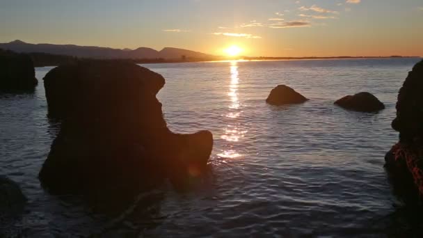 波飛沫、飛ぶスプレー水で美しく反射太陽の光と海の下で明るい夕日 — ストック動画