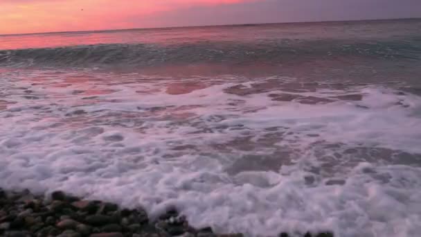 Escena del atardecer del mar con colorida iluminación solar sobre nubes, olas y arena en primer plano — Vídeo de stock