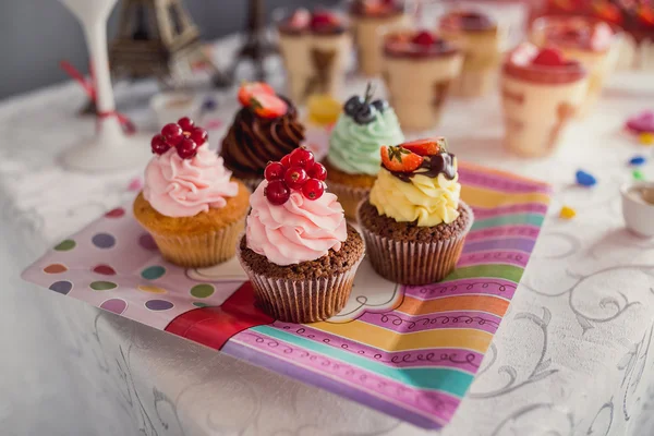 Heerlijke cupcakes met bessen op een plaat op feestelijke tabel clos — Stockfoto