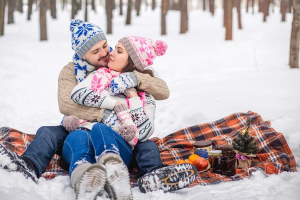 Casal apaixonado abraçando no parque de inverno e sentado no bla — Fotografia de Stock