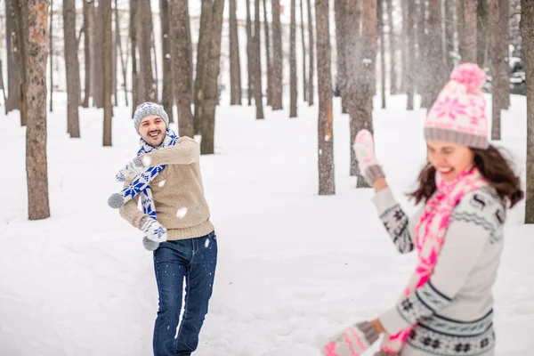 Combattimento con le palle di neve. inverno coppia avendo divertente giocare in neve all'aperto — Foto Stock