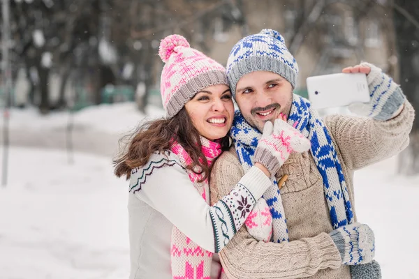 Coppia innamorata sorridente e fare selfie in inverno all'aperto — Foto Stock