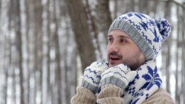 Güzel örgü kazak, eşarp, şapka ve eldiven kış ormandaki sakallı erkek hippi. Adam onun kış giysileri düzeltir