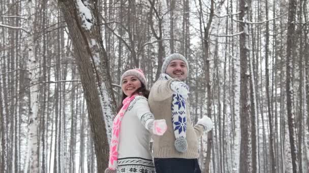 Pareja joven teniendo una pelea de bolas de nieve en un campo de nieve — Vídeos de Stock