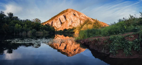 Göl günbatımı tepenin yansıma ile. Shihan, Bashkortosta