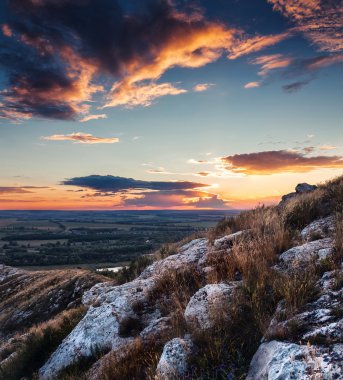 Parlak ve renkli günbatımı dokulu ön planda Vadisi'ndeki taş ve kayalar