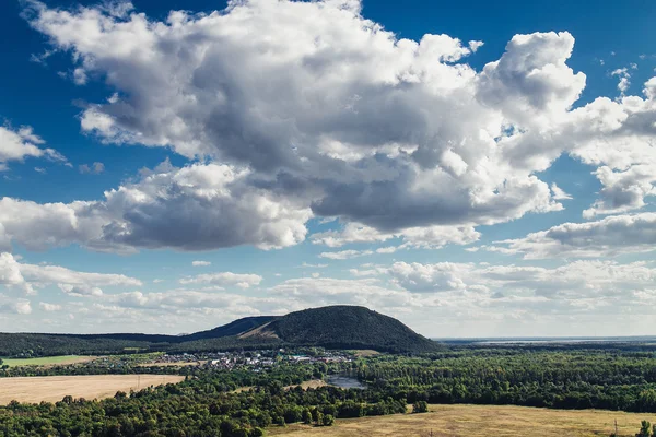 Flygfoto över kullen med skog, åkrar och liten by — Stockfoto