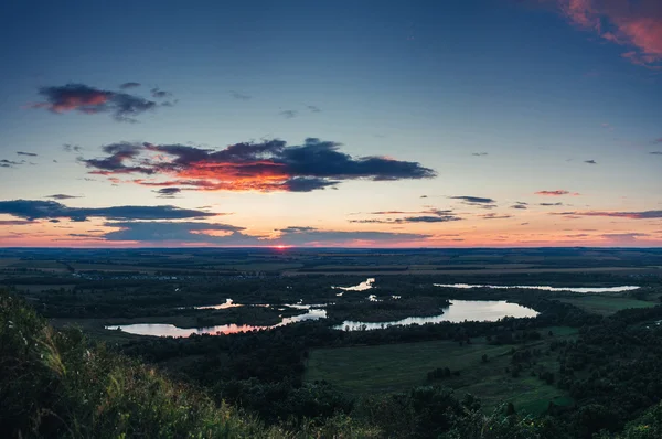 Vista dall'alto: lago al tramonto con campo valle — Foto Stock
