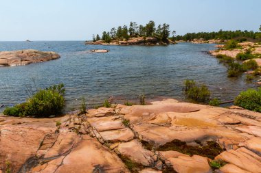 Huron Gölü boyunca uzanan granit kıyı şeridi. Kanada, Ontario 'daki Killarney İl Parkı' ndaki Gürcistan Körfezi 'ndeki Chikanishing Deresi' nin ağzındaki granit kayalar.