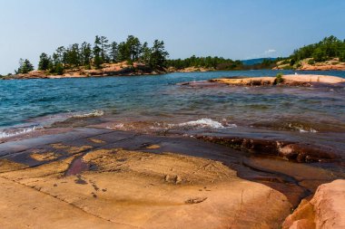 Huron Gölü boyunca uzanan granit kıyı şeridi. Kanada, Ontario 'daki Killarney İl Parkı' ndaki Gürcistan Körfezi 'ndeki Chikanishing Deresi' nin ağzındaki granit kayalar.