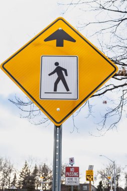 Yaya geçitleri için sarı uyarı işareti, üzerinde yürüyen bir adamın resmi var. Ontario, Kanada.