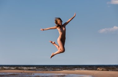 Çıplak kadın deniz arka plan üzerinde atlama