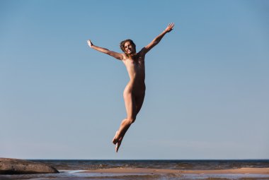 Çıplak kadın deniz arka plan üzerinde atlama