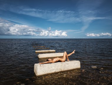 Denizin üzerinde güneşlenme çıplak kadın