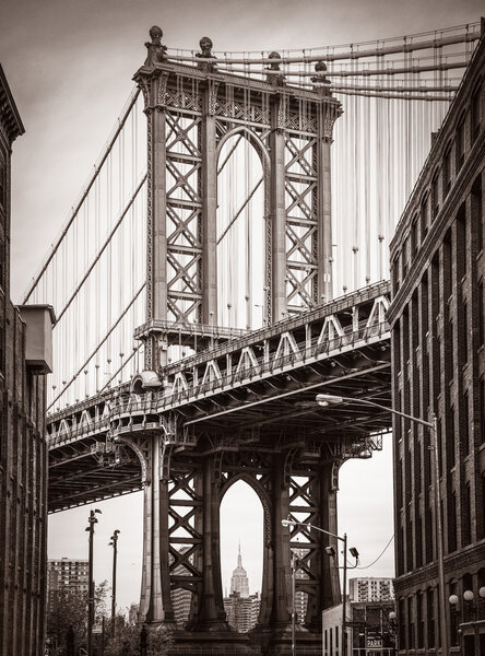 Manhattan Bridge and Empire State Building seen from Brooklyn, New York. Old photo stylization, film grain added. Sepia toned