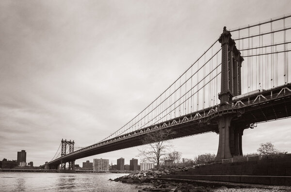 Manhattan Bridge, New York, USA on an overcast day. Old photo stylization, film grain added. Sepia toned