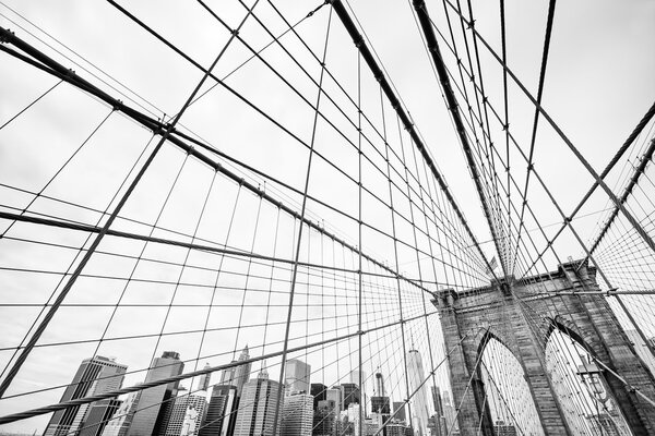 Black and white image of the Brooklyn Bridge in New York. Manhattan skyline in background