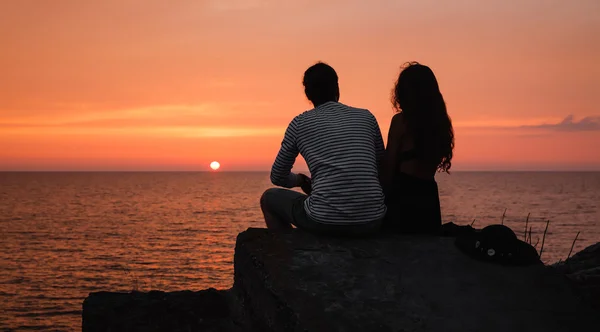 Junges verliebtes Paar gegen Sonnenuntergang auf See — Stockfoto