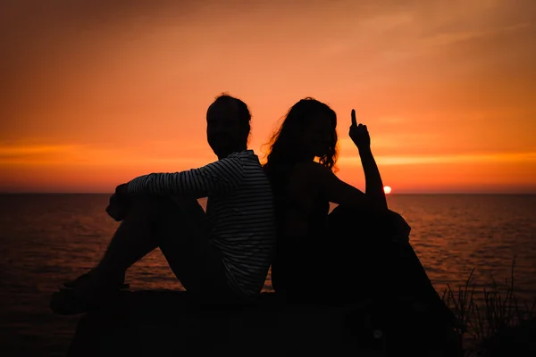 Mladý pár v lásce vůči západu slunce na moři — Stock fotografie