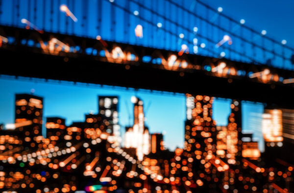 Blurred lights of Manhattan Skyline and Manhattan Bridge At Night. Manhattan Bridge is a suspension bridge that crosses the East River in New York City