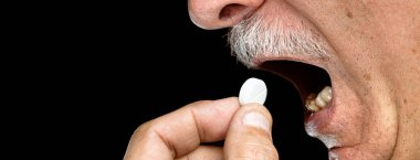 Yaklaş ihtiyar, siyah arka planda hap al. Kopyalama alanı olan resim.