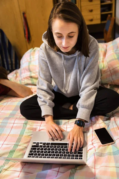 ホームオフィスとリモートワークの概念 若い女性は自宅のコンピュータ上でリモートで動作しますコロナウイルスのパンデミックの間にソファに座っている間 — ストック写真