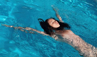 Açık havada çıplak bir kadın. Yüzme havuzunda genç ve güzel bir kadın..